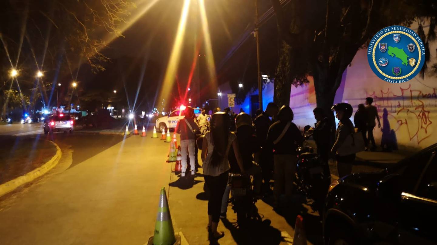 Un grupo de personas en una calle de noche

Descripción generada automáticamente